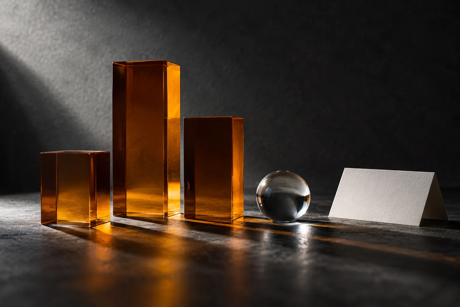 Abstract amber glass blocks and clear sphere beside a blank card