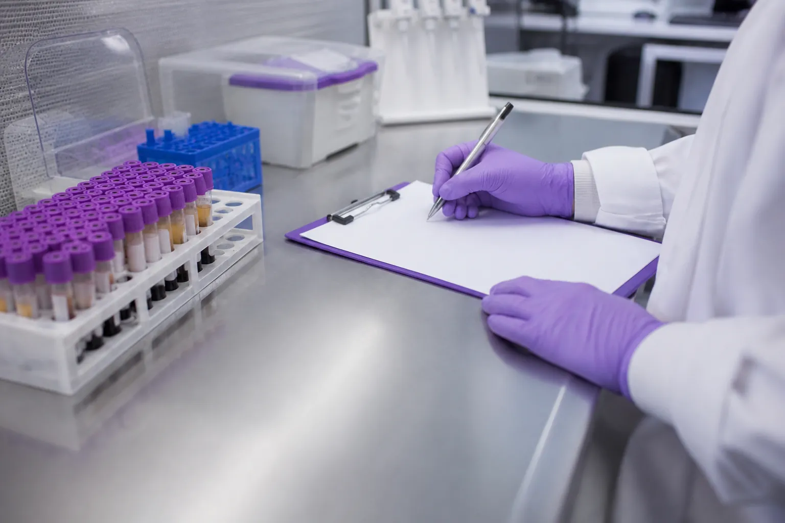 Laboratory technician checking anonymised blood sample tubes