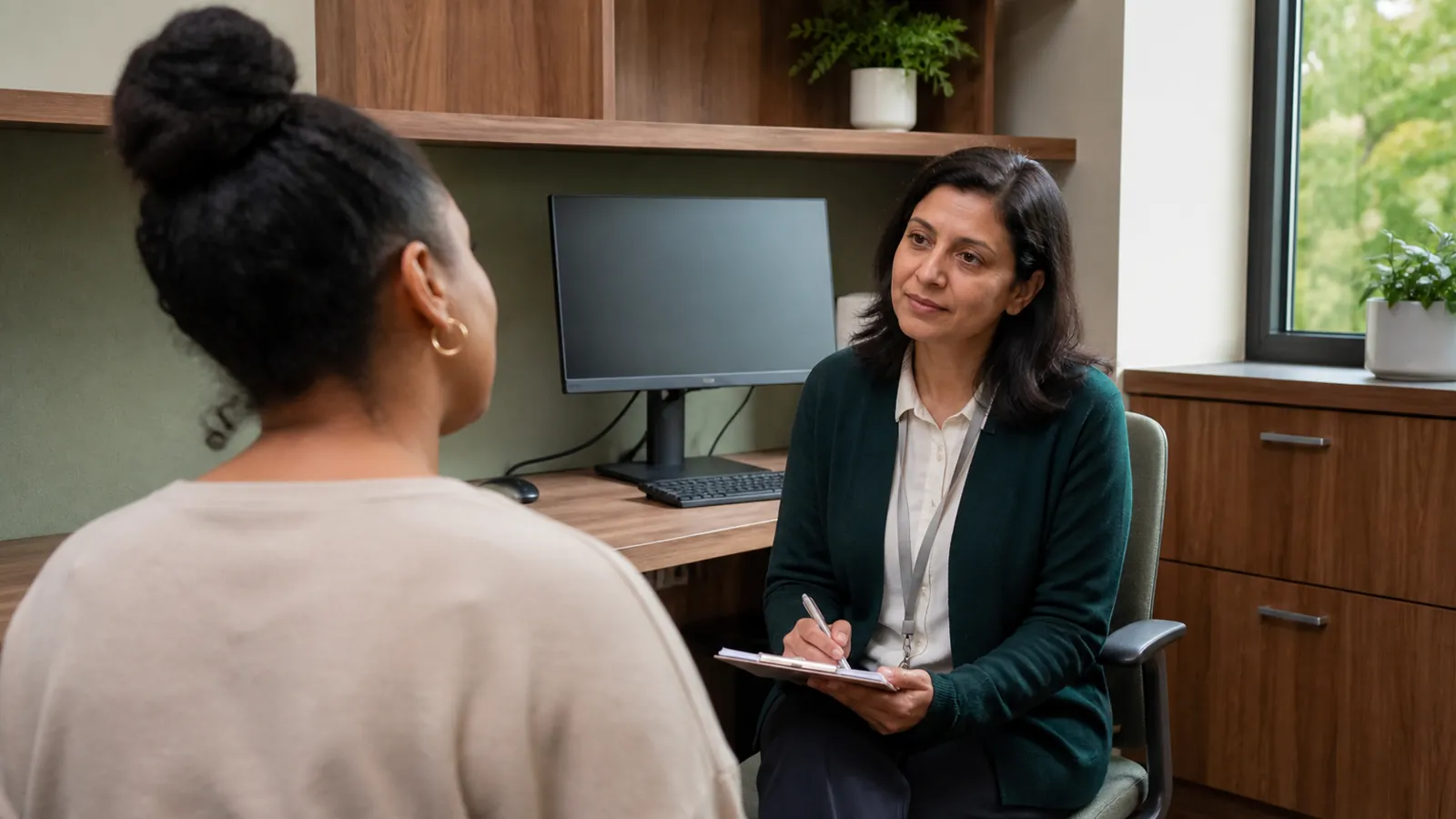 Patient discussing persistent symptoms with a clinician in a consultation room